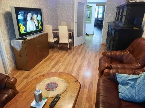 a living room with a couch and a television and a table at Apartament Mazurski in Szczytno