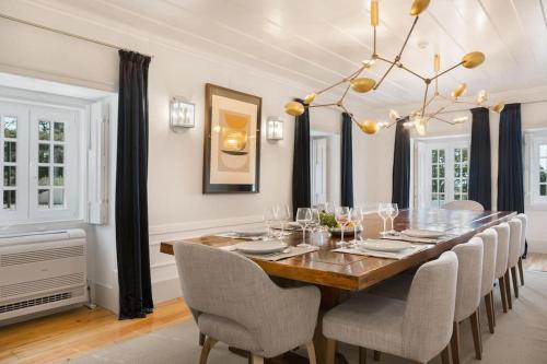 a dining room with a table with chairs and a chandelier at Casa do Presidente in Lisbon