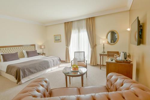 une chambre d'hôtel avec un lit et un canapé dans l'établissement Acropole Tunis, à Tunis