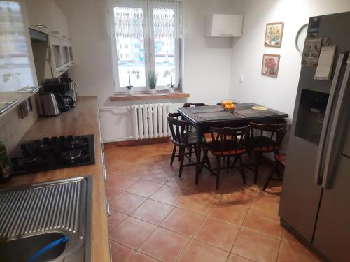 a kitchen with a table and chairs in a kitchen at Apartament Mazurski in Szczytno