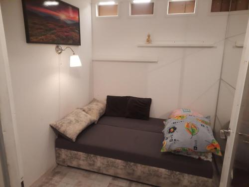 Habitación pequeña con sofá y almohadas en Apartament Mazurski, en Szczytno