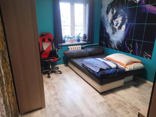 a room with a bed and a chair in it at Apartament Mazurski in Szczytno