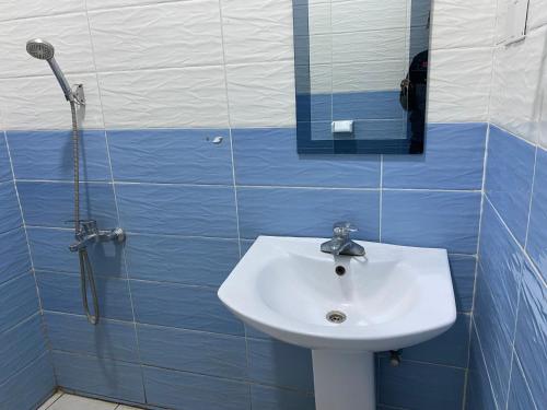 a bathroom with a sink and a shower with a mirror at Virunga Homestays in Ruhengeri