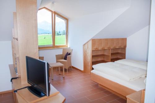 een slaapkamer met een bed en een tv in een kamer bij Haus Geier in Rieden