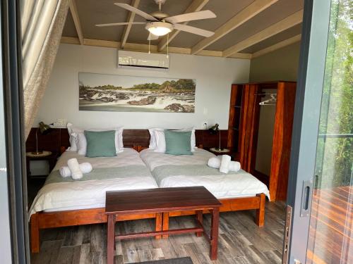 a bedroom with a bed with a table in it at White Sands Lodge in Divundu