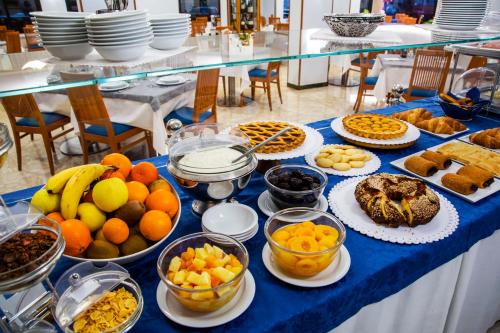 a table topped with bowls of fruit and other foods at Hotel Mediterranée in Spotorno