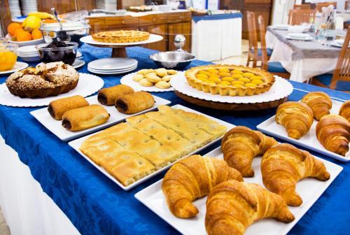 a table topped with different types of bread and pastries at Hotel Mediterranée in Spotorno