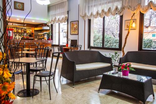 a restaurant with tables and chairs and a bar at Hotel Mediterranée in Spotorno