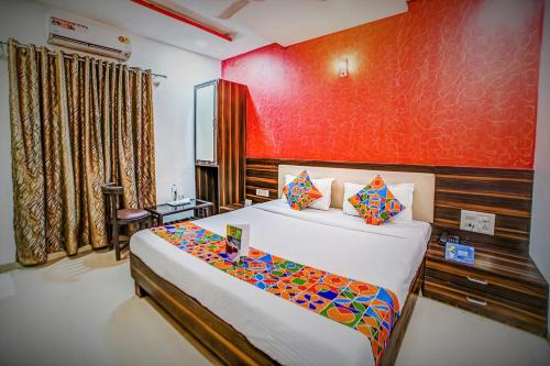 a bedroom with a bed and a red wall at Hotel Adore Palace - Near Mumbai Airport & Visa Consulate in Mumbai
