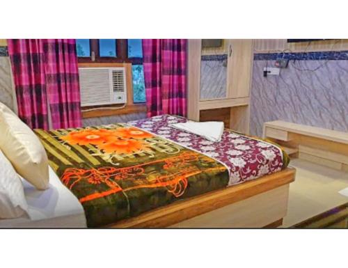 Un dormitorio con una cama con flores naranjas. en Hotel Kuber, Bhabua, en Bhabua