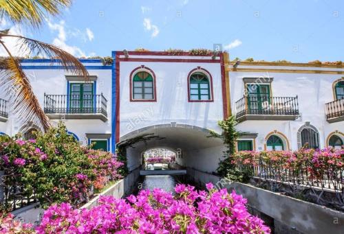an exterior view of a building with pink flowers at VV VELERO in Puerto de Mogán
