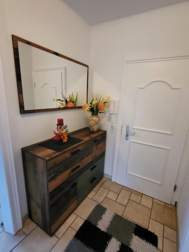 a room with a mirror and a dresser with flowers on it at Fewo Ostsee in Graal-Müritz