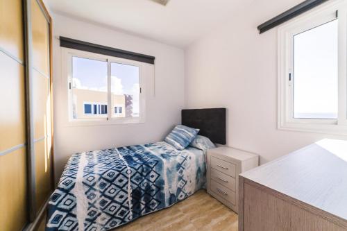 Un dormitorio con una cama y dos ventanas. en Maspalomas,Flipper, en Maspalomas