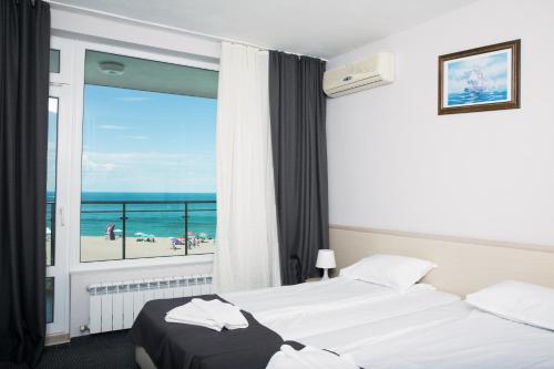 a hotel room with two beds and a view of the beach at Family Hotel Sunrise in Lozenets