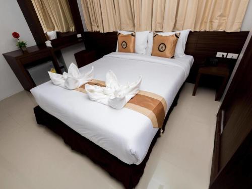 um quarto com duas camas com flores brancas em Royal Asia Hotel Pratunam em Bangkok