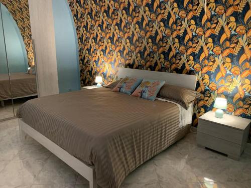 カノーザ・ディ・プーリアにあるCasa - Torre dell'Orologioの花柄の壁紙を用いたベッドルーム1室(大型ベッド1台付)