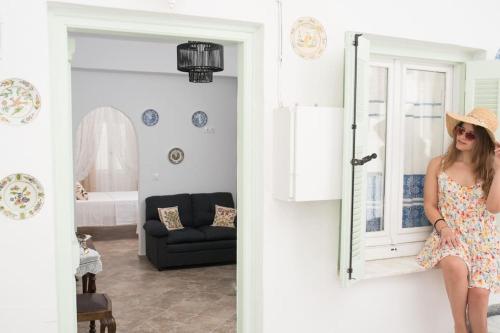 a woman in a dress is standing in a room at Katoi House - Central Skyros Village in Skiros