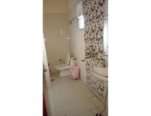 a bathroom with a toilet and a sink at Hotel Kanha Dham, Kanpur in Kānpur