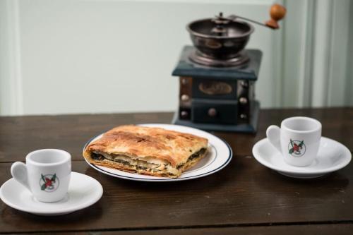 a sandwich on a plate on a table with two cups at Katoi House - Central Skyros Village in Skiros