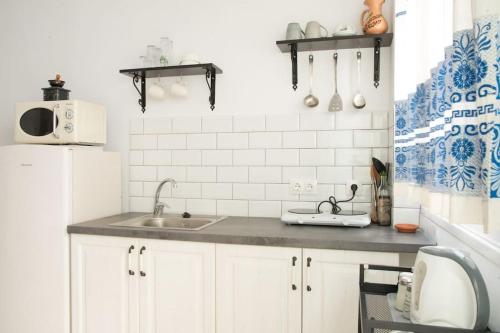 a kitchen with a sink and a white refrigerator at Katoi House - Central Skyros Village in Skiros