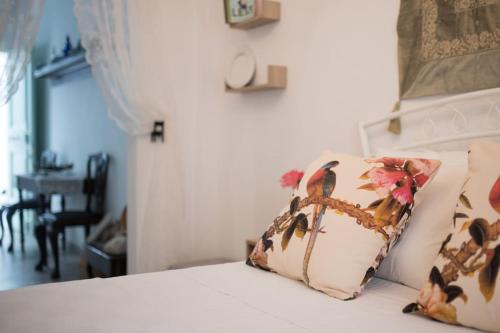 a bed with a pillow with flowers on it at Katoi House - Central Skyros Village in Skiros