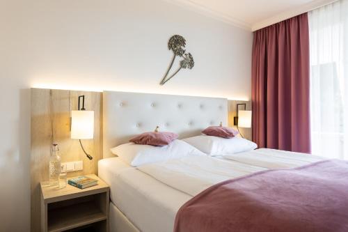 a hotel room with a large bed and a window at Boutiquehotel Bergvilla in Dafins