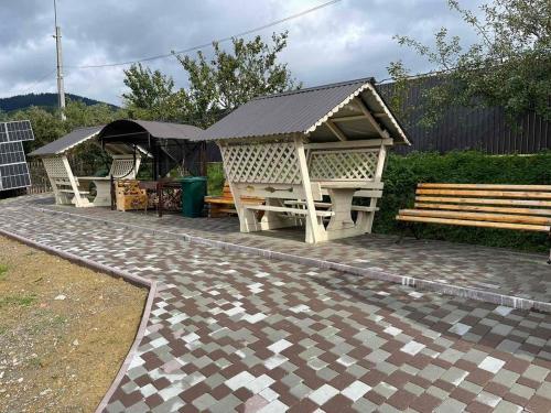 a wooden bench and a table and a bench and a table and a bench at Садиба Кичера Gold in Mizhhirʼʼya