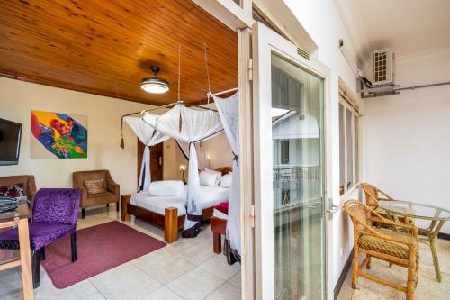 a room with a bedroom with a bed and a window at 2 Friends Beach Hotel in Entebbe