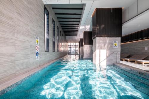 - une piscine dans un bâtiment d'eau bleue dans l'établissement Mega Style Apartments Victoria One, à Melbourne