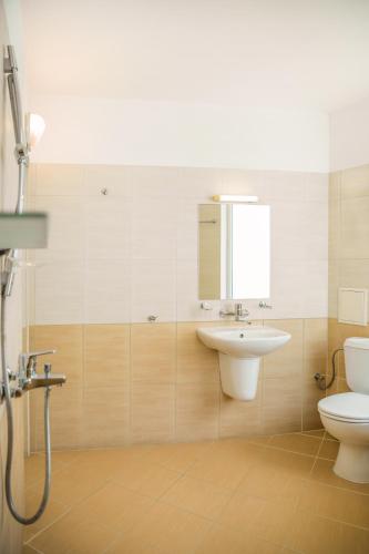 a bathroom with a toilet and a sink at Family Hotel Sunrise in Lozenets