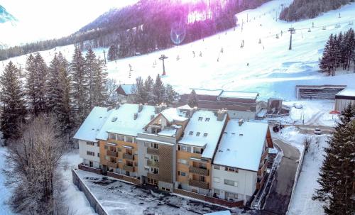 a building on a ski slope with snow on it at Apartments Plan Kranjska Gora in Kranjska Gora