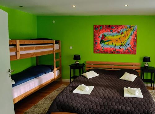 a green bedroom with two bunk beds and a painting at STOP&RELAX Apartment in Liptovská Osada