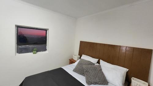 um quarto com uma cama grande e uma janela em Hilltop em Uitenhage