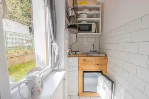 eine kleine Küche mit einem Waschbecken und einem Fenster in der Unterkunft Luna Pokoje Gościnne in Szklarska Poręba