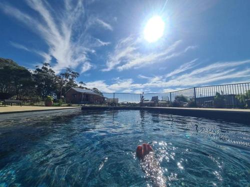 a person in a swimming pool with the sun in the sky at Bukirk Glamping & Fancy Coops in Clare