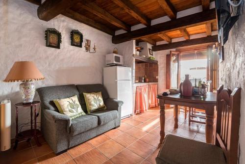sala de estar con mesa, sofá y cocina en CASA PETRA en Miranda del Castañar