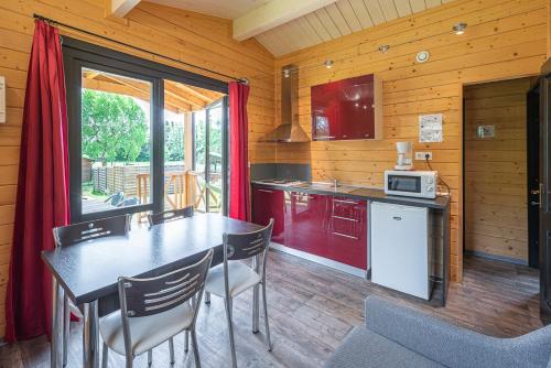 eine Küche mit einem Tisch und Stühlen in einer Hütte in der Unterkunft Camping Au pays de Hanau in Dossenheim-sur-Zinsel
