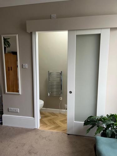 a bathroom with a door leading to a toilet at Pilgrims Retreat in Kent
