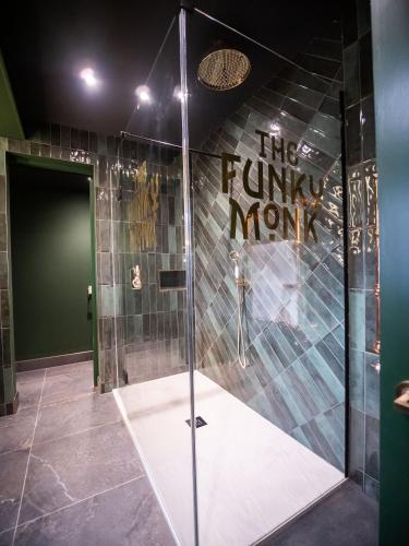 a shower with a glass door in a room at The Funky Monk in Durham
