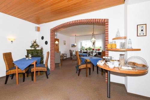 jadalnia z niebieskimi stołami i krzesłami w obiekcie Hotel-Pension Marlies w mieście Neuharlingersiel
