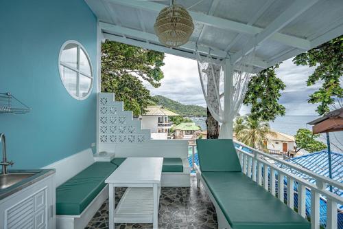 a balcony with green benches and a table at DD Hut Koh Tao in Koh Tao