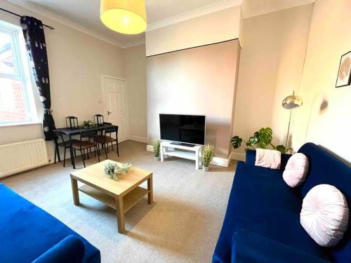 a living room with a blue couch and a table at Close to city centre-Quayside bright apartment in Gateshead