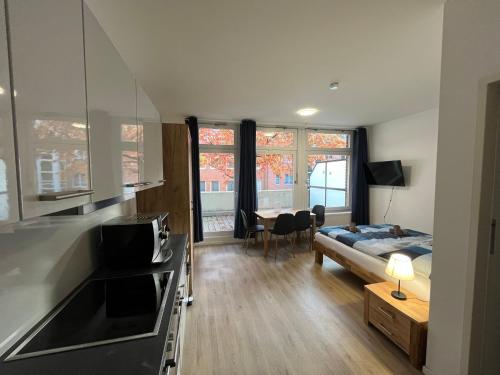 a living room with a bed and a kitchen and a bedroom at Basement Küchgarten in Hamburg
