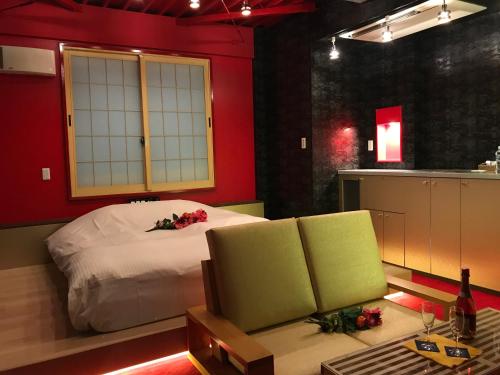 a bedroom with a bed and a table and a kitchen at ホテル 鳳凰 大人専用 in Hachioji