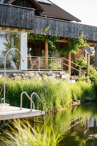 a wooden dock in front of a house on a river at Biohof Ebenbauer in Waidhofen an der Ybbs