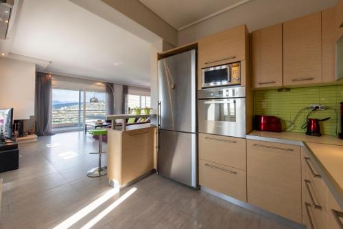 a kitchen with stainless steel appliances and a large window at Harmony Maisonette in Schinias