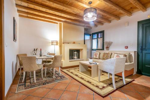 - un salon avec une table, des chaises et un canapé dans l'établissement The Varos Residences Hotel, à Város