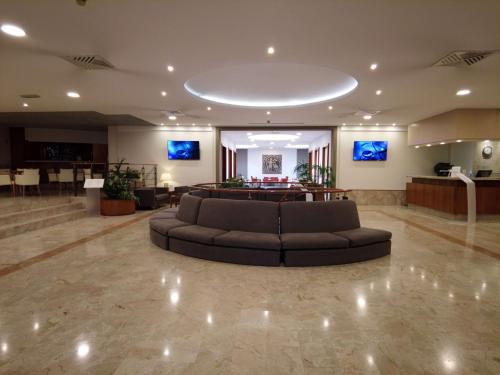 un gran vestíbulo con un sofá en el medio en Best Western Park Hotel en Piacenza