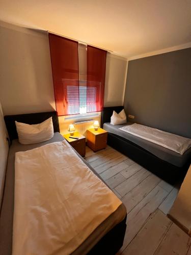 Habitación pequeña con 2 camas y ventana en Landhaus Spickermann, en Xanten