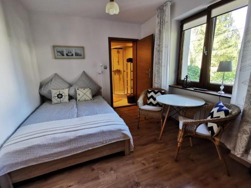 a bedroom with a bed and a table and chairs at Apartamenty Villa 28 in Pobierowo